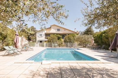 Mobilier de jardin en bois avec coussins blancs, comprenant un canapé, deux fauteuils et une table basse, sur pelouse.