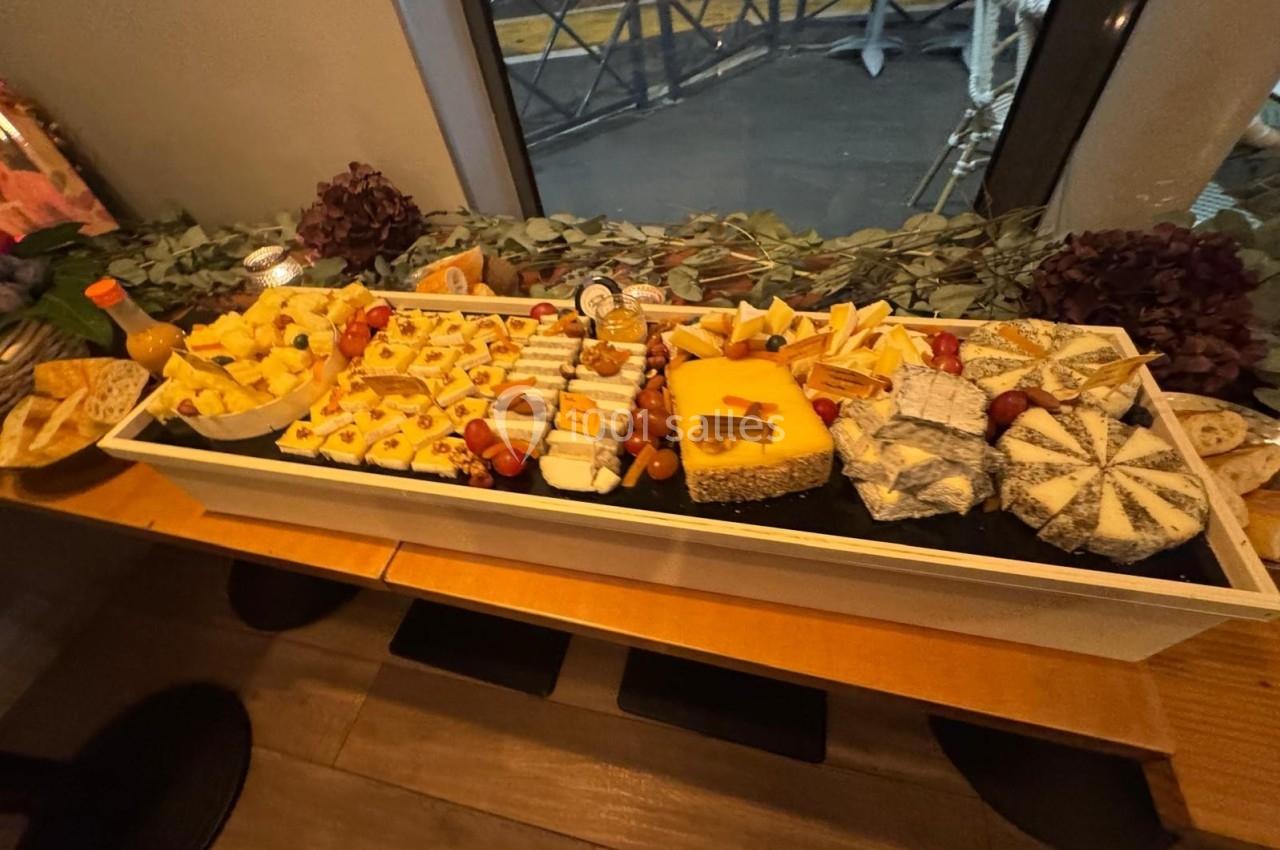 Plateau de fromages variés avec accompagnements, présenté sur une table en bois dans un cadre intérieur.