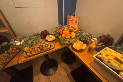 Plateau de fromages variés avec fruits secs, raisins et condiments, disposé sur une table en bois décorée de feuillage.
