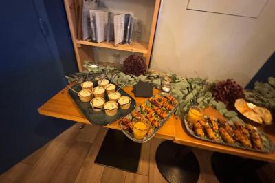 Plateau de fromages variés avec fruits secs, raisins et condiments, disposé sur une table en bois décorée de feuillage.