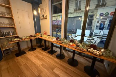 Plateau de fromages variés avec fruits secs, raisins et condiments, disposé sur une table en bois décorée de feuillage.