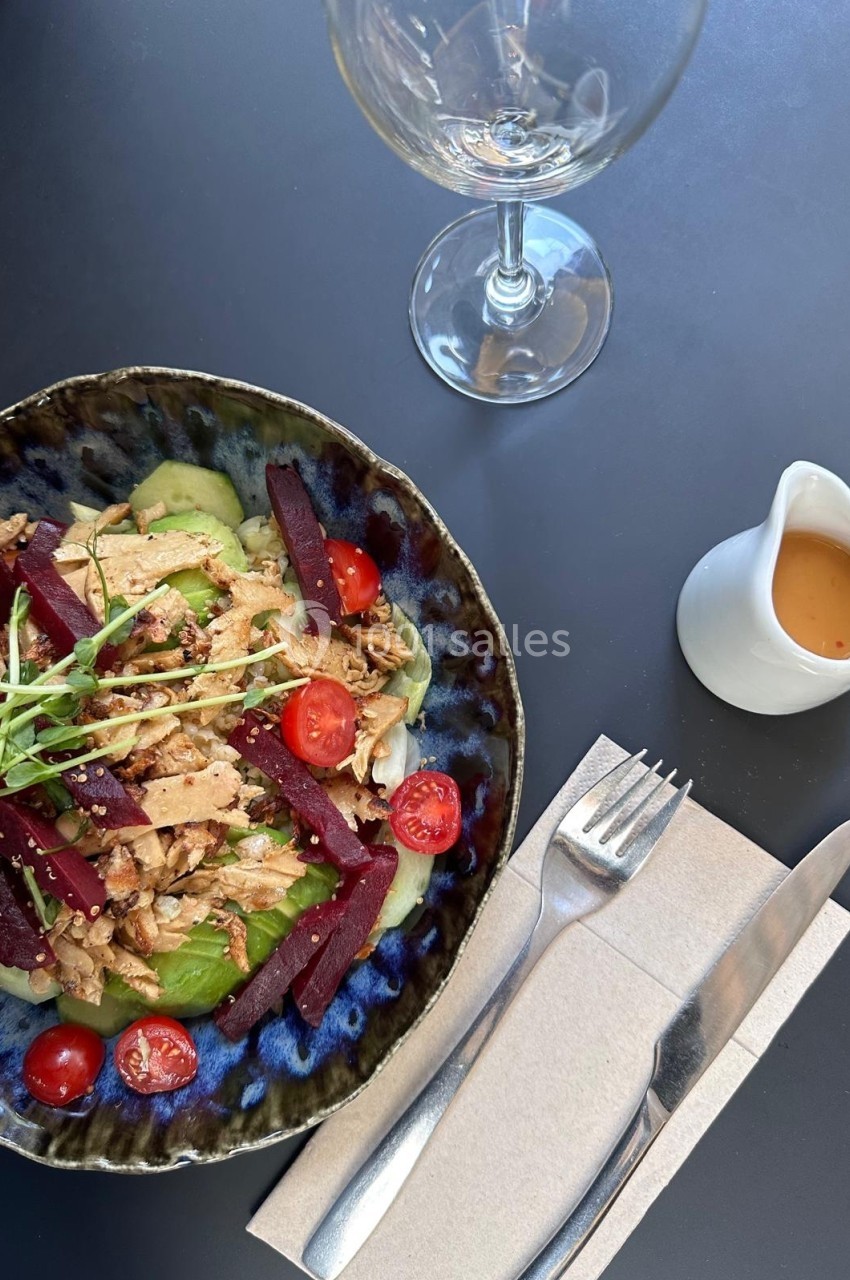 Salade composée avec légumes frais, betteraves, tomates cerises, noix et tofu, servie avec une vinaigrette à part.