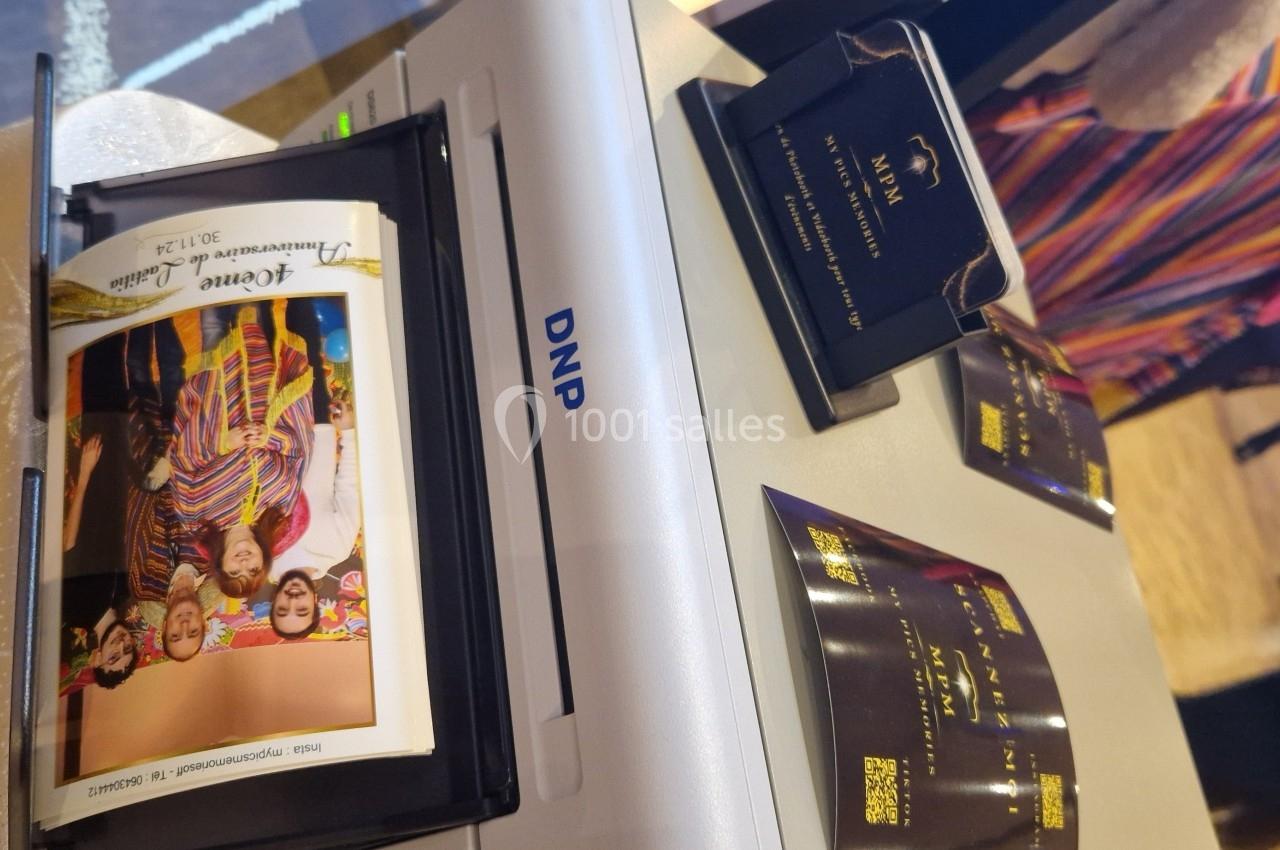 Photo imprimée sortant d'une imprimante DNP, avec des personnes en vêtements colorés visibles sur l'image.