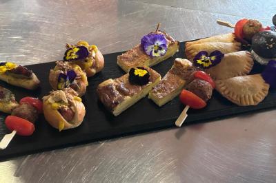 Assiette de foie gras avec pain et fleurs comestibles, accompagnée d'une salade colorée sur une autre assiette.