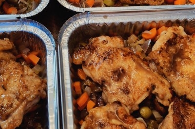 Poulets rôtis disposés dans des barquettes en aluminium, accompagnés de légumes coupés en petits morceaux.