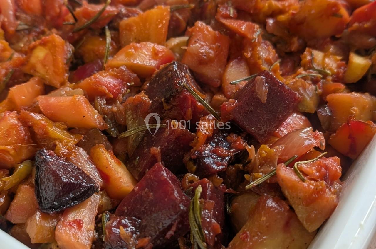 Plat de légumes rôtis comprenant betteraves, pommes de terre et herbes, présenté dans un plat blanc.