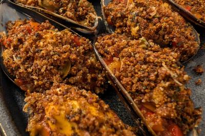 Une personne découpe un petit oignon sur une planche, entourée de légumes frais et d'herbes aromatiques.