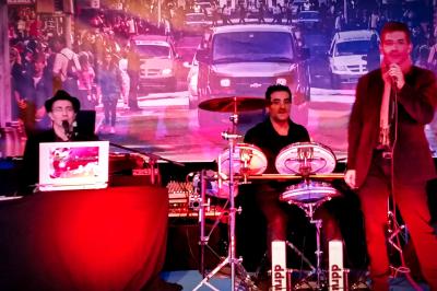 Miniature DJ Pantin (Seine-Saint-Denis) - Frontiere Live #25 Un groupe de musiciens joue sur scène, avec une chanteuse, un accordéoniste, un saxophoniste et un pianiste.