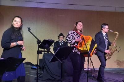 Miniature DJ Pantin (Seine-Saint-Denis) - Frontiere Live #36 Un groupe de musiciens joue sur scène, avec une chanteuse, un accordéoniste, un saxophoniste et un pianiste.