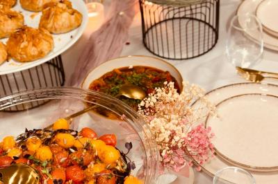 Tranches d'orange garnies de groseilles, pétales de fleurs, amandes effilées et feuilles de menthe dans une assiette.