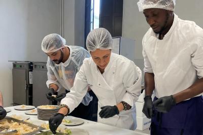 Tranches d'orange garnies de groseilles, pétales de fleurs, amandes effilées et feuilles de menthe dans une assiette.