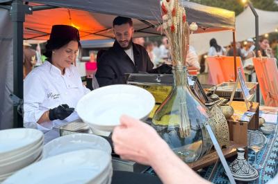 Tranches d'orange garnies de groseilles, pétales de fleurs, amandes effilées et feuilles de menthe dans une assiette.