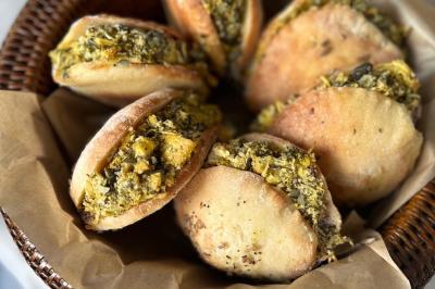 Tranches d'orange garnies de groseilles, pétales de fleurs, amandes effilées et feuilles de menthe dans une assiette.