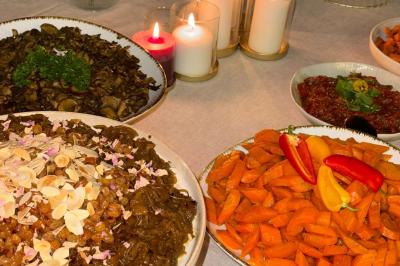 Tranches d'orange garnies de groseilles, pétales de fleurs, amandes effilées et feuilles de menthe dans une assiette.