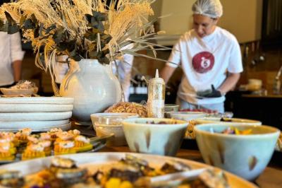 Tranches d'orange garnies de groseilles, pétales de fleurs, amandes effilées et feuilles de menthe dans une assiette.