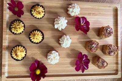 Tranches d'orange garnies de groseilles, pétales de fleurs, amandes effilées et feuilles de menthe dans une assiette.