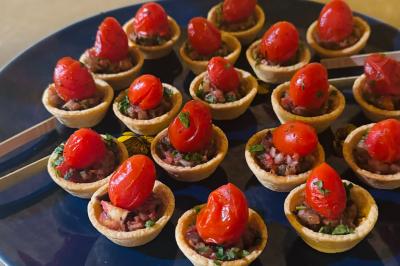 Tranches d'orange garnies de groseilles, pétales de fleurs, amandes effilées et feuilles de menthe dans une assiette.