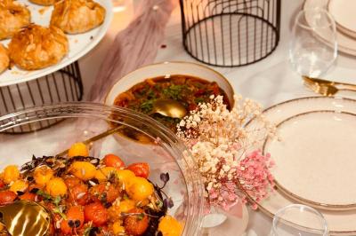 Tranches d'orange garnies de groseilles, pétales de fleurs, amandes effilées et feuilles de menthe dans une assiette.