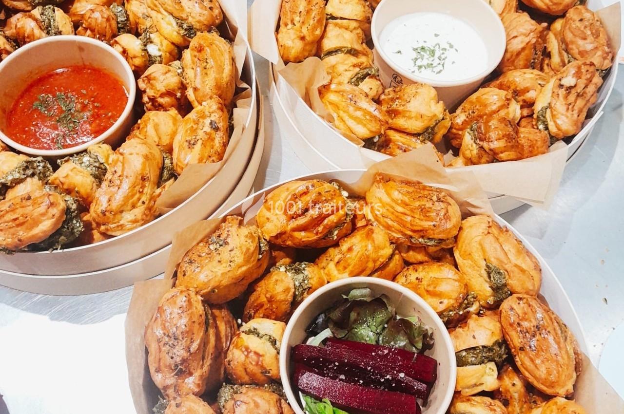 Plateaux garnis de bouchées feuilletées dorées, accompagnées de sauces et de betteraves en garniture.