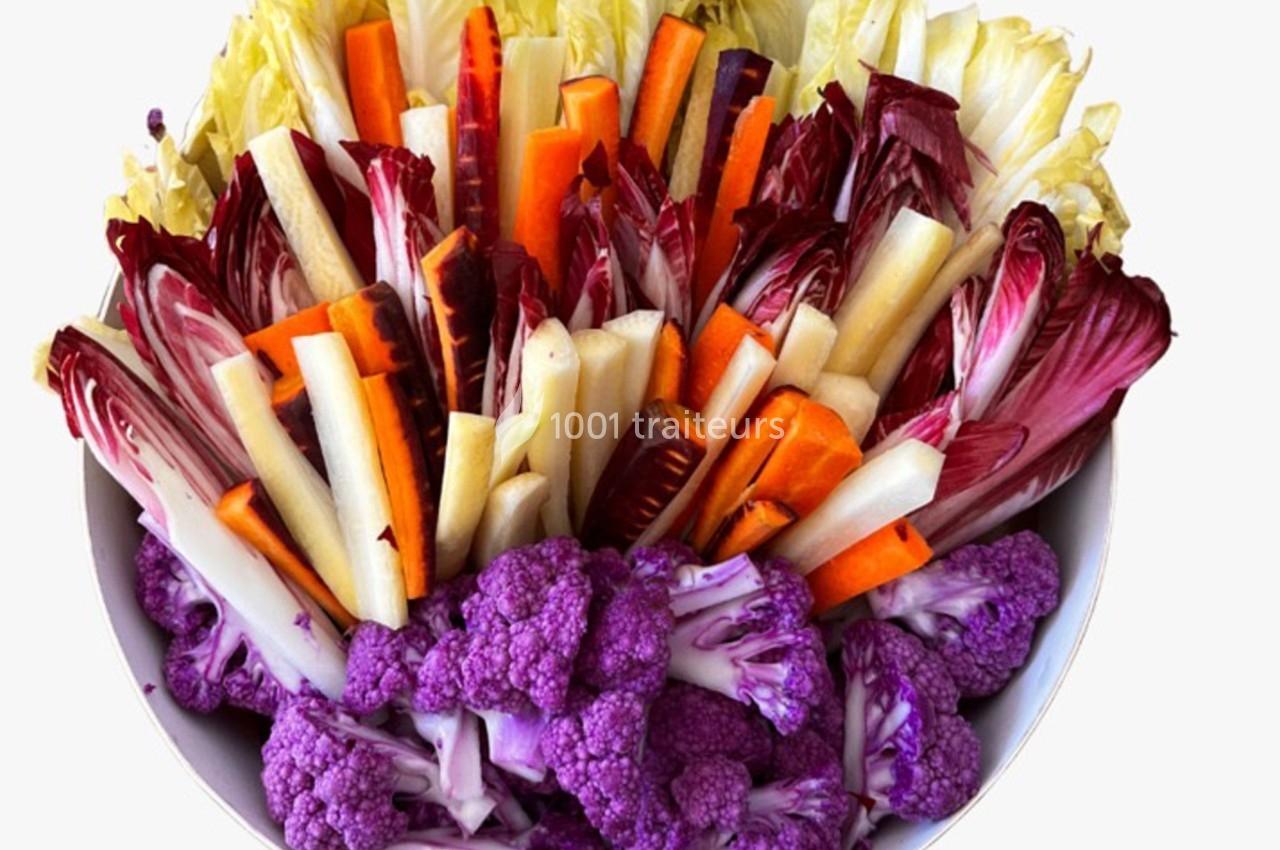 Assortiment de légumes crus colorés comprenant choux-fleurs violets, endives, carottes et autres légumes coupés.