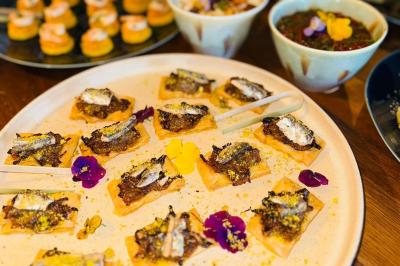 Tranches d'orange garnies de groseilles, pétales de fleurs, amandes effilées et feuilles de menthe dans une assiette.