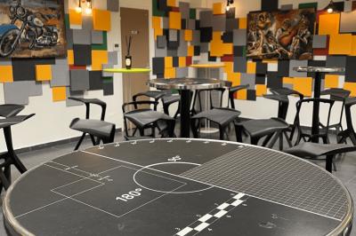 Accueil avec comptoir noir, décoration murale, tableau coloré, et éclairage au plafond dans un espace moderne.