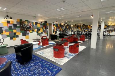 Accueil avec comptoir noir, décoration murale, tableau coloré, et éclairage au plafond dans un espace moderne.