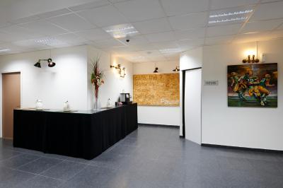 Accueil avec comptoir noir, décoration murale, tableau coloré, et éclairage au plafond dans un espace moderne.