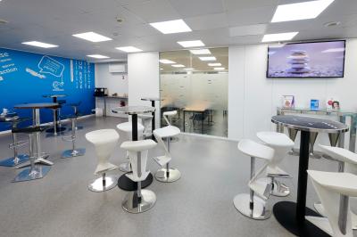 Accueil avec comptoir noir, décoration murale, tableau coloré, et éclairage au plafond dans un espace moderne.