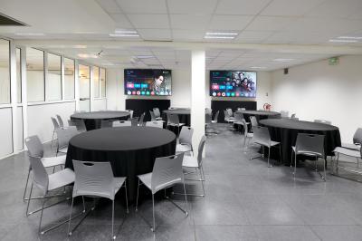 Accueil avec comptoir noir, décoration murale, tableau coloré, et éclairage au plafond dans un espace moderne.