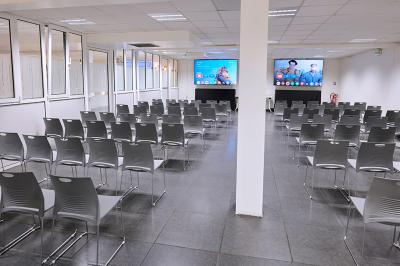 Espace de pause avec comptoir noir, décorations murales, tableau coloré et éclairage chaleureux.