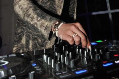 Main ajustant des commandes sur une table de mixage dans un environnement sombre.