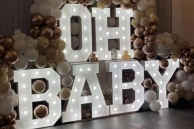 Mur décoratif sur le thème des années 90 avec graffitis colorés, ballons blancs et dorés, et accessoires rétro.