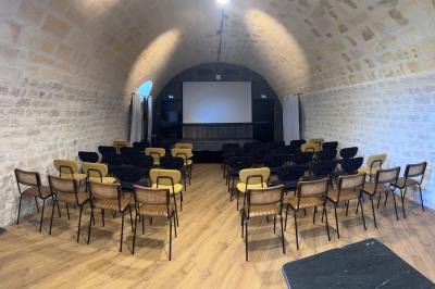 Salle à manger lumineuse avec une grande table en bois, chaises assorties, lustre, et décoration classique.