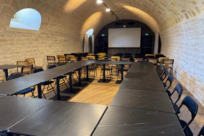 Salle à manger lumineuse avec une grande table en bois, chaises assorties, lustre, et décoration classique.