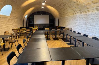 Salle à manger lumineuse avec une grande table en bois, chaises assorties, lustre, et décoration classique.