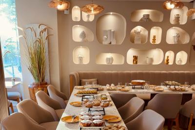 Des personnes assises à des tables dans un restaurant, discutant et partageant un repas dans une ambiance conviviale.