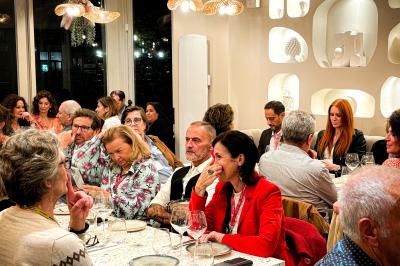 Des personnes assises à des tables dans un restaurant, discutant et partageant un repas dans une ambiance conviviale.