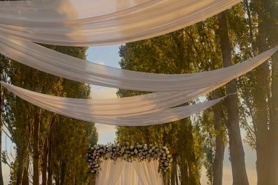 Salle à manger et salon avec table en bois, canapés clairs, lampes suspendues et lumière naturelle.
