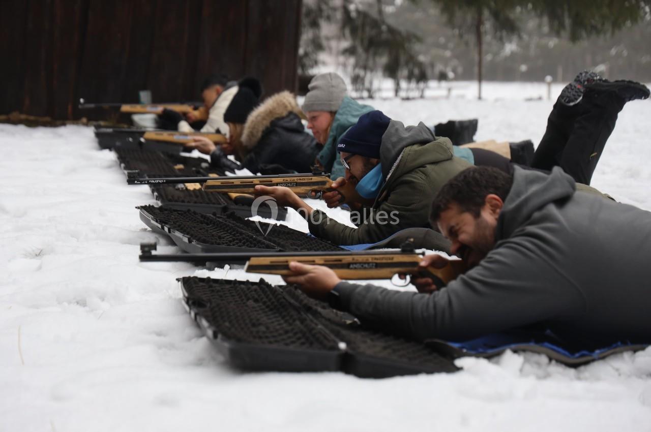 Location salle Crozets (Jura) - Domaine Le Coupet #14 Des personnes allongées sur la neige participent à une séance de tir avec des carabines, en extérieur.