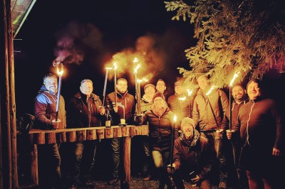 Miniature Location salle Crozets (Jura) - Domaine Le Coupet #26 Un groupe de personnes tenant des torches allumées, rassemblées dehors la nuit près d'une cabane en bois.