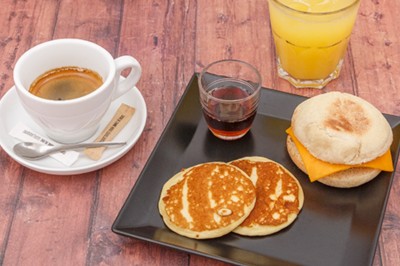 Comptoir blanc avec logo ’Medtronic’ sur une terrasse ensoleillée, entouré de plantes et vue sur des bâtiments historiques.