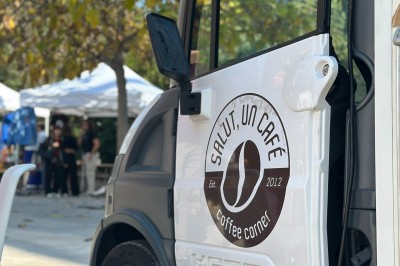 Comptoir blanc avec logo ’Medtronic’ sur une terrasse ensoleillée, entouré de plantes et vue sur des bâtiments historiques.