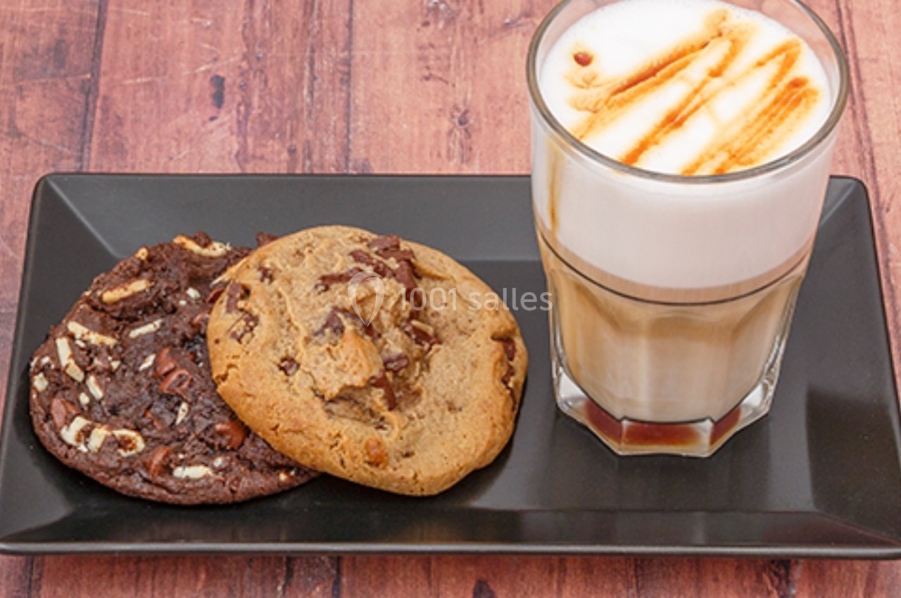 Un latte avec caramel accompagné de deux cookies, l'un au chocolat noir et l'autre aux pépites de chocolat.