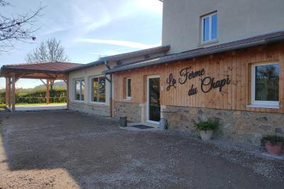 Salle à manger avec table en bois, chaises assorties, escalier en bois, et cuisine ouverte dans un intérieur chaleureux.