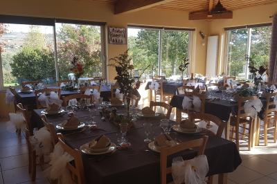 Salle à manger avec table en bois, chaises assorties, escalier en bois, et cuisine ouverte dans un intérieur chaleureux.