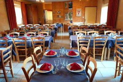 Salle à manger avec table en bois, chaises assorties, escalier en bois, et cuisine ouverte dans un intérieur chaleureux.