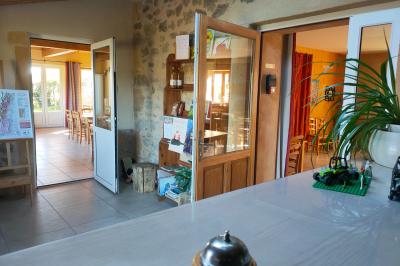 Salle à manger avec table en bois, chaises assorties, escalier en bois, et cuisine ouverte dans un intérieur chaleureux.