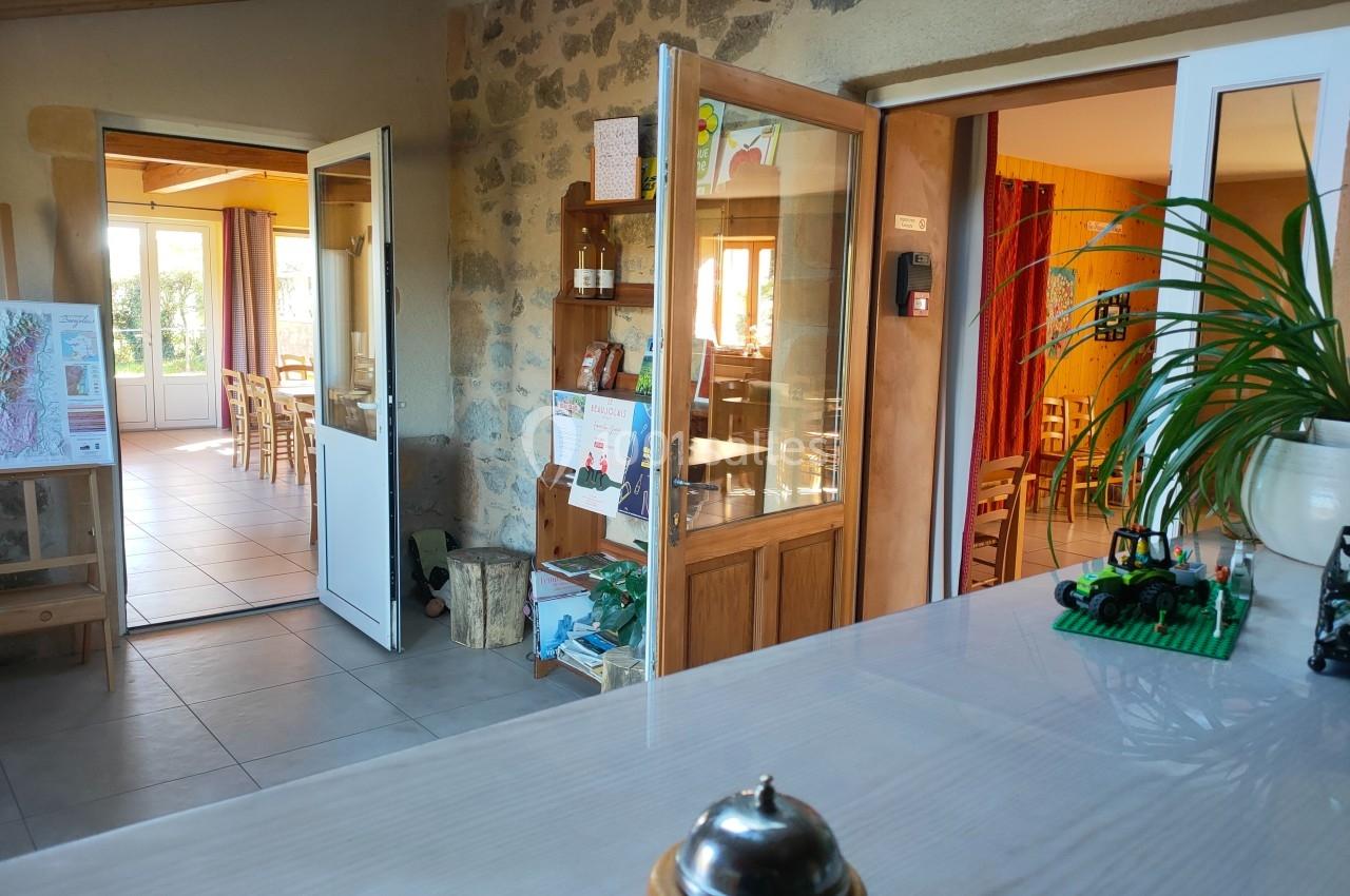 Vue intérieure d'un espace accueillant avec des portes ouvertes sur des salles lumineuses et une plante sur un comptoir.