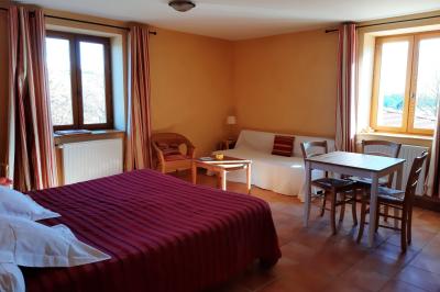 Salle à manger avec table en bois, chaises assorties, escalier en bois, et cuisine ouverte dans un intérieur chaleureux.